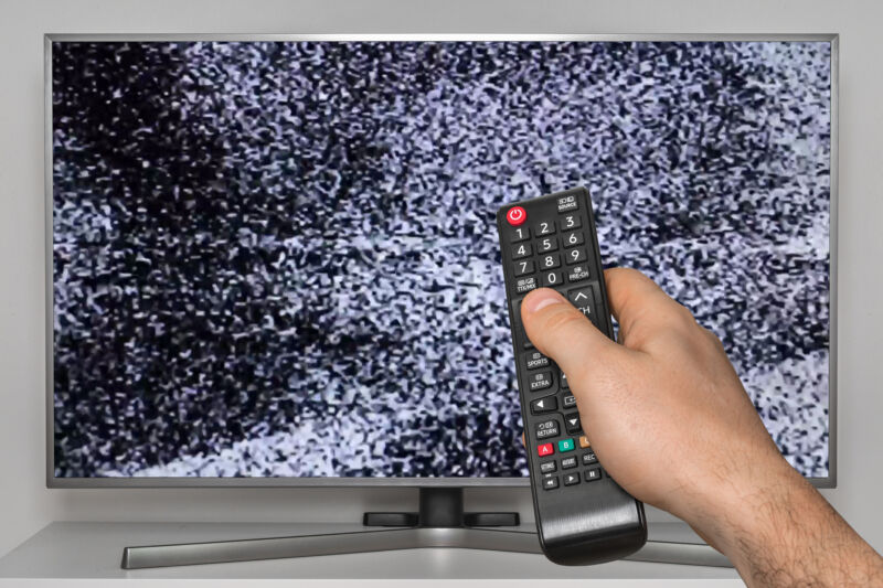 scrambled tv TV with human hand with TV remote control