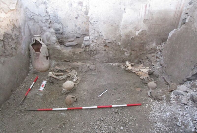 two skeletons in the rubble of a Pompeii archaeological site